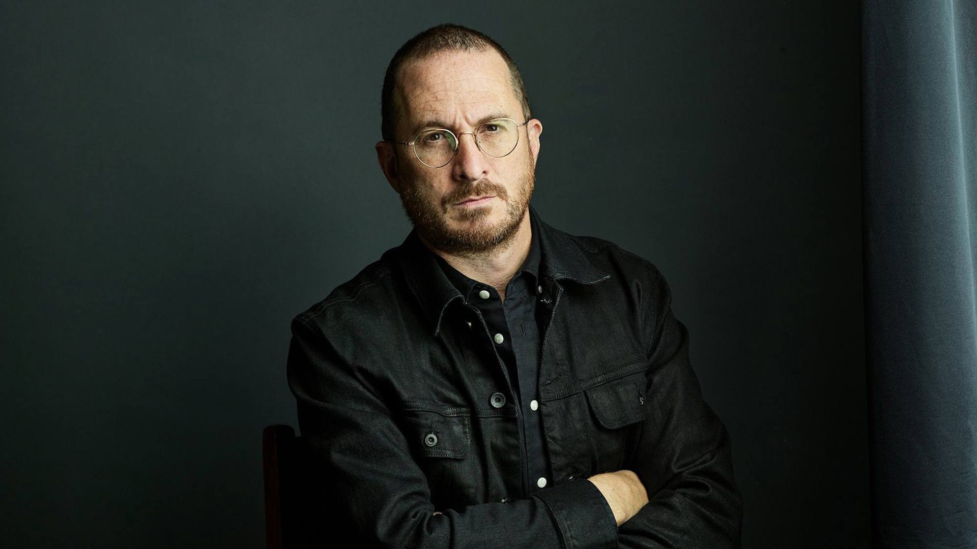 Retrato en tonos oscuros de un hombre con barba y gafas