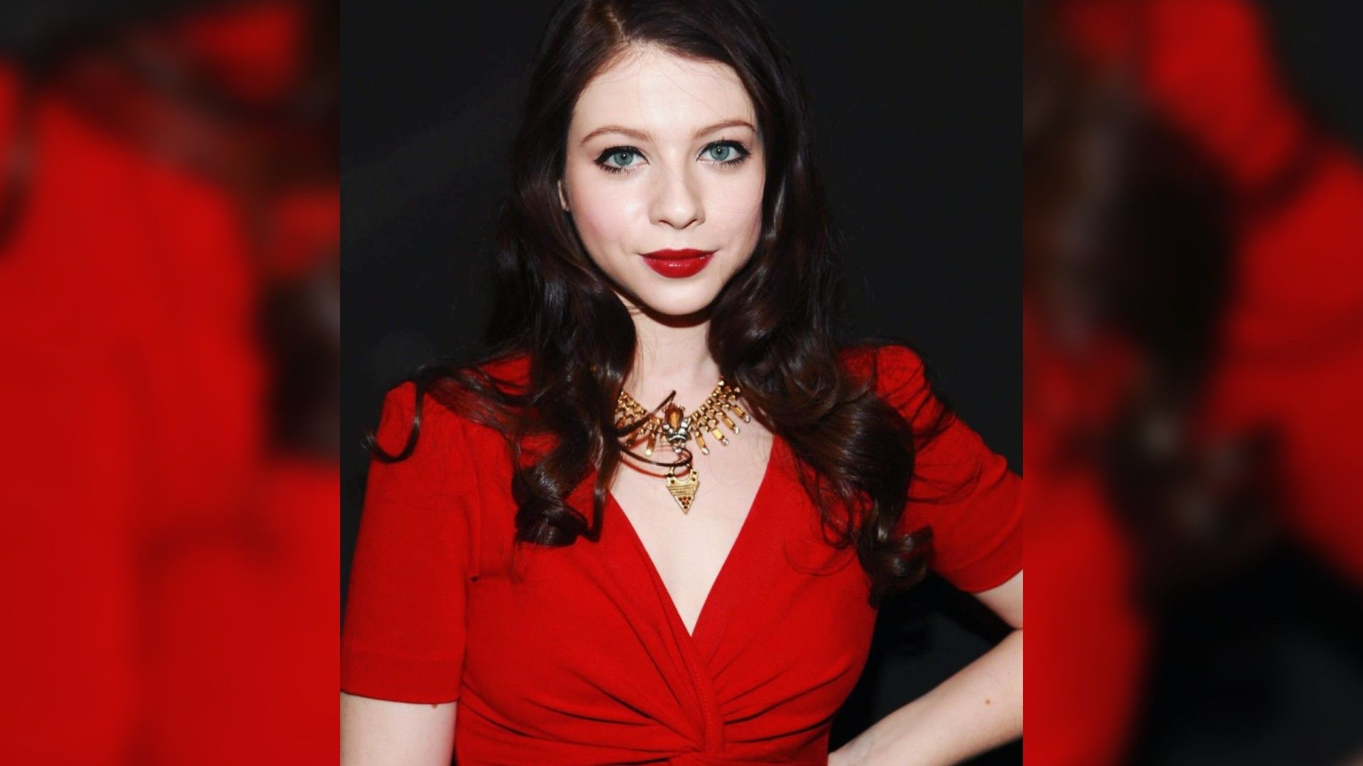 Actriz Michelle Trachtenberg en un vestido rojo y maquillaje llamativo con lápiz labial rojo que coincide con el color del vestido