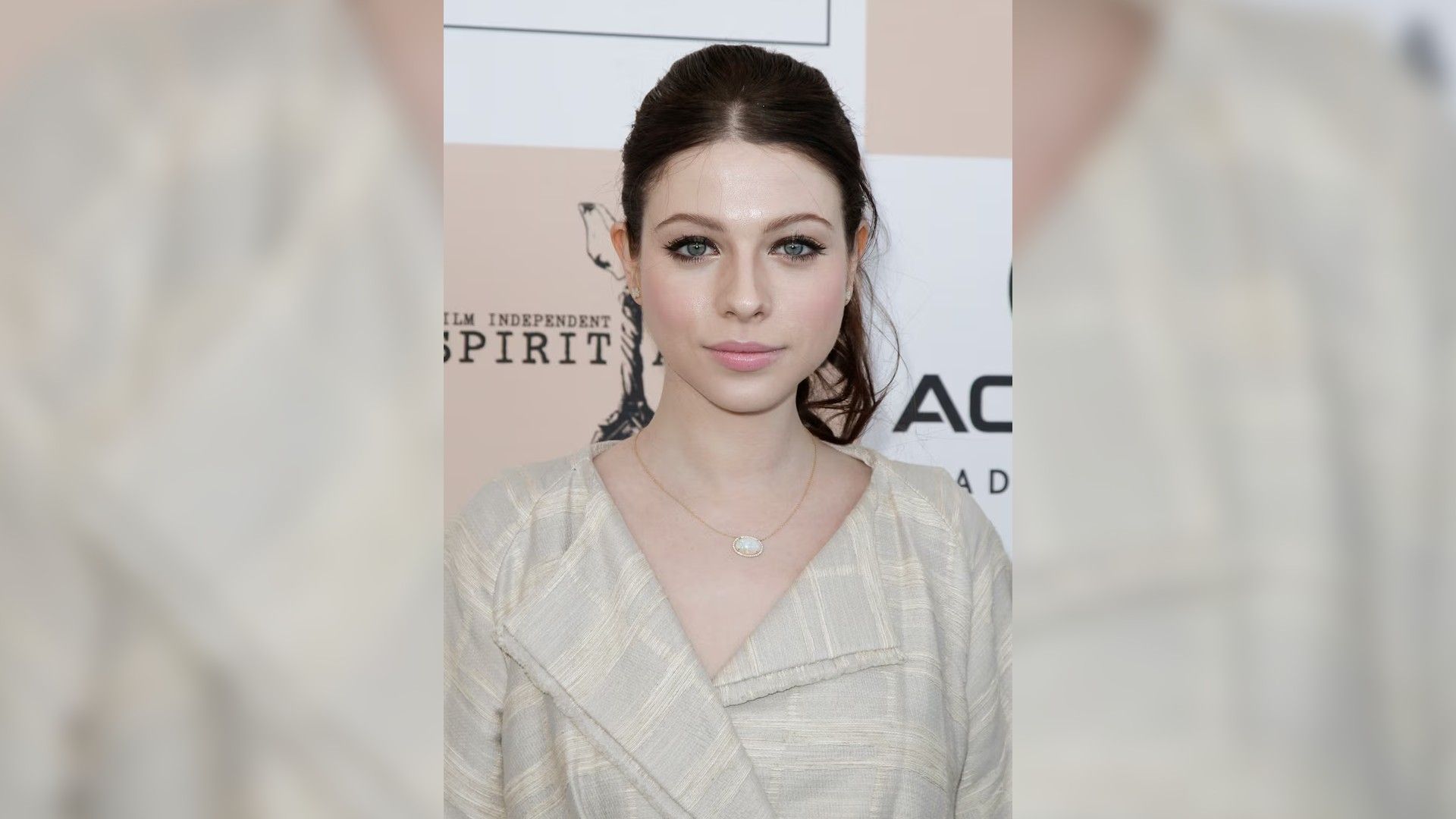 Michelle Trachtenberg con una camisa blanca, el cabello recogido