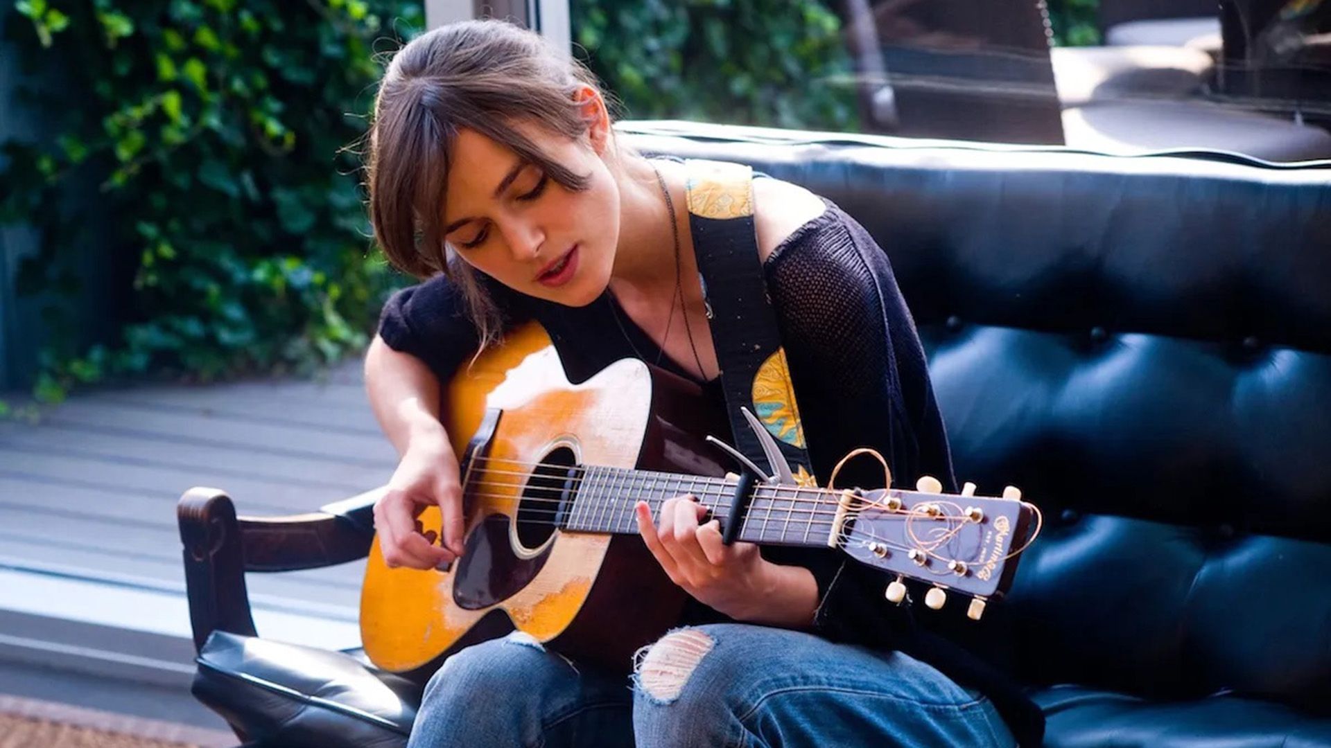 La chica está tocando la guitarra afuera