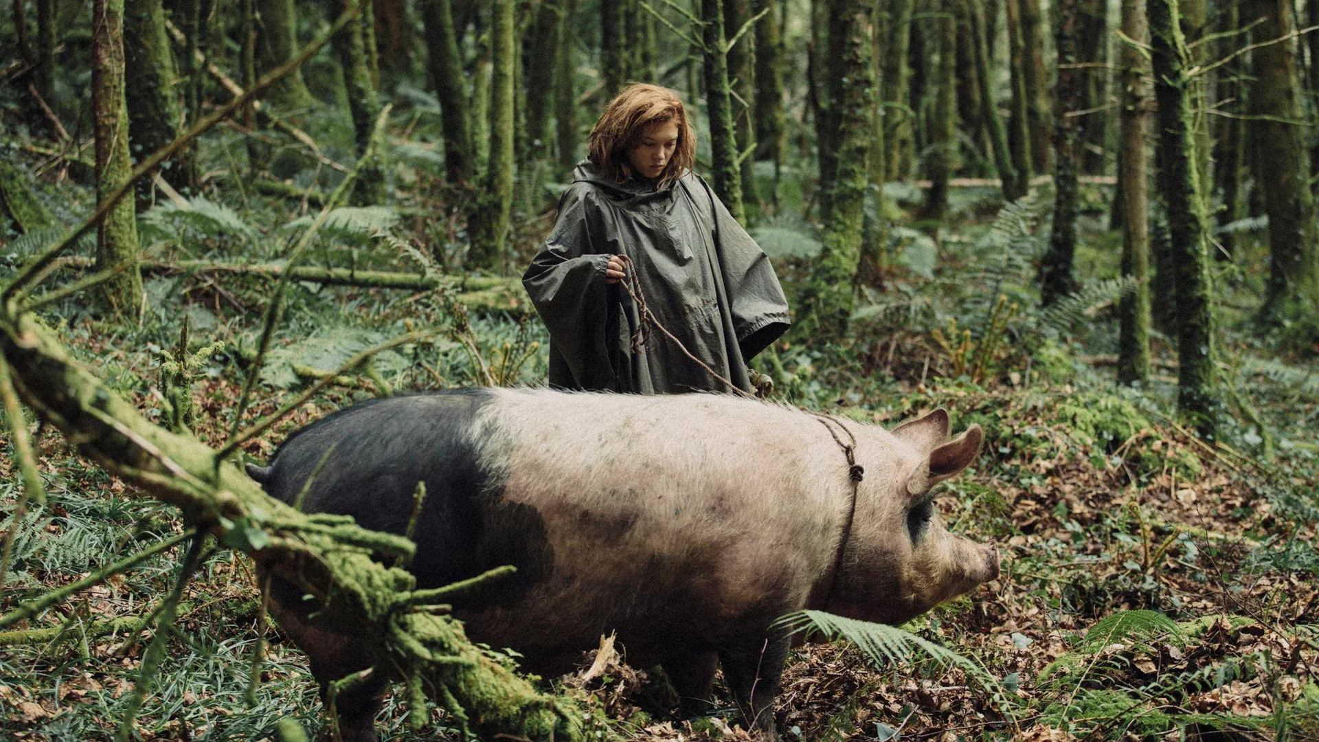 Una chica en el bosque llevando un cerdo con una cuerda