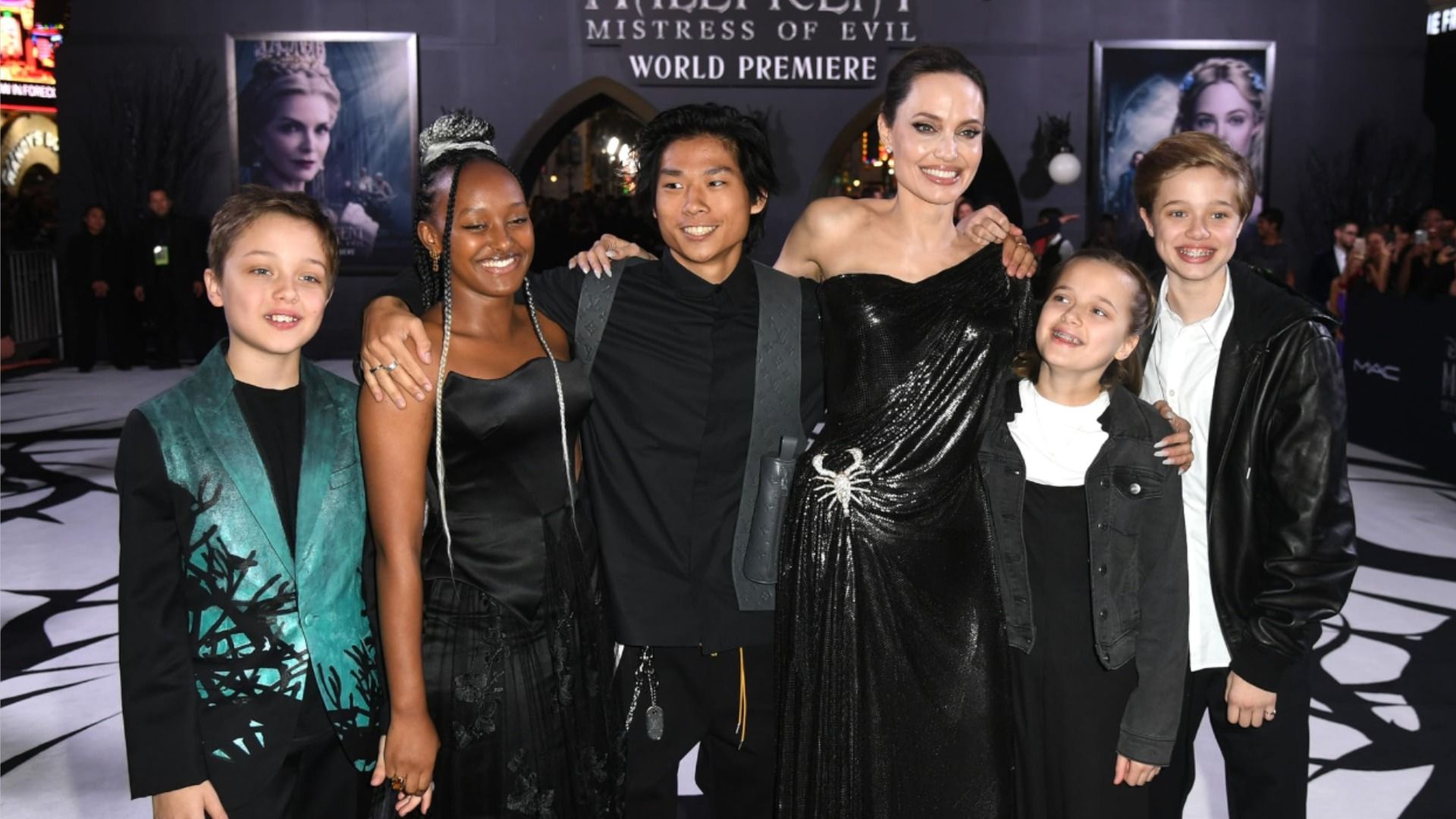 Actriz Angelina Jolie sonríe frente a la cámara con sus hijos