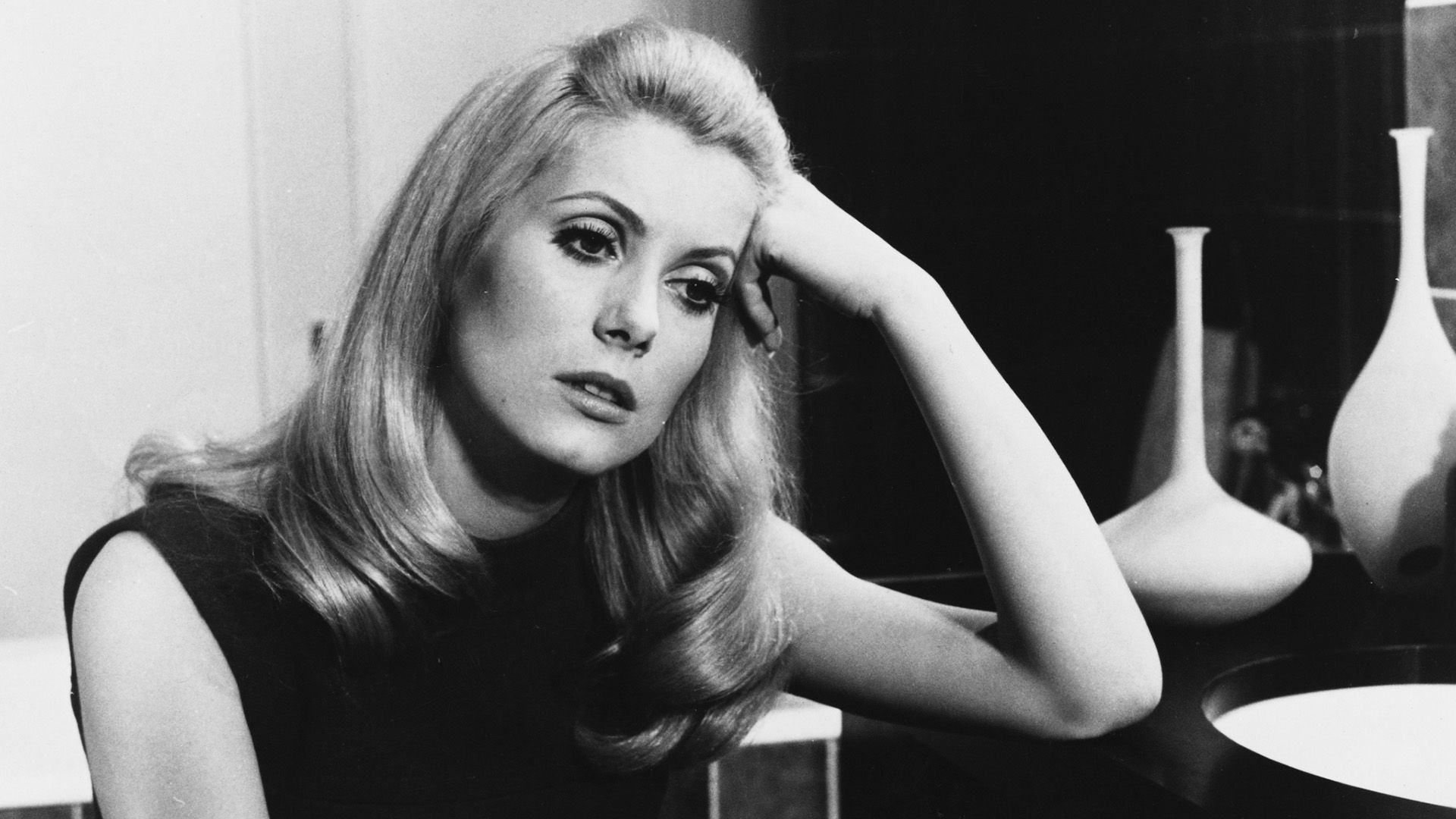 Catherine Deneuve se apoya pensativa en la mesa en una escena de la película 'Belle de Jour'