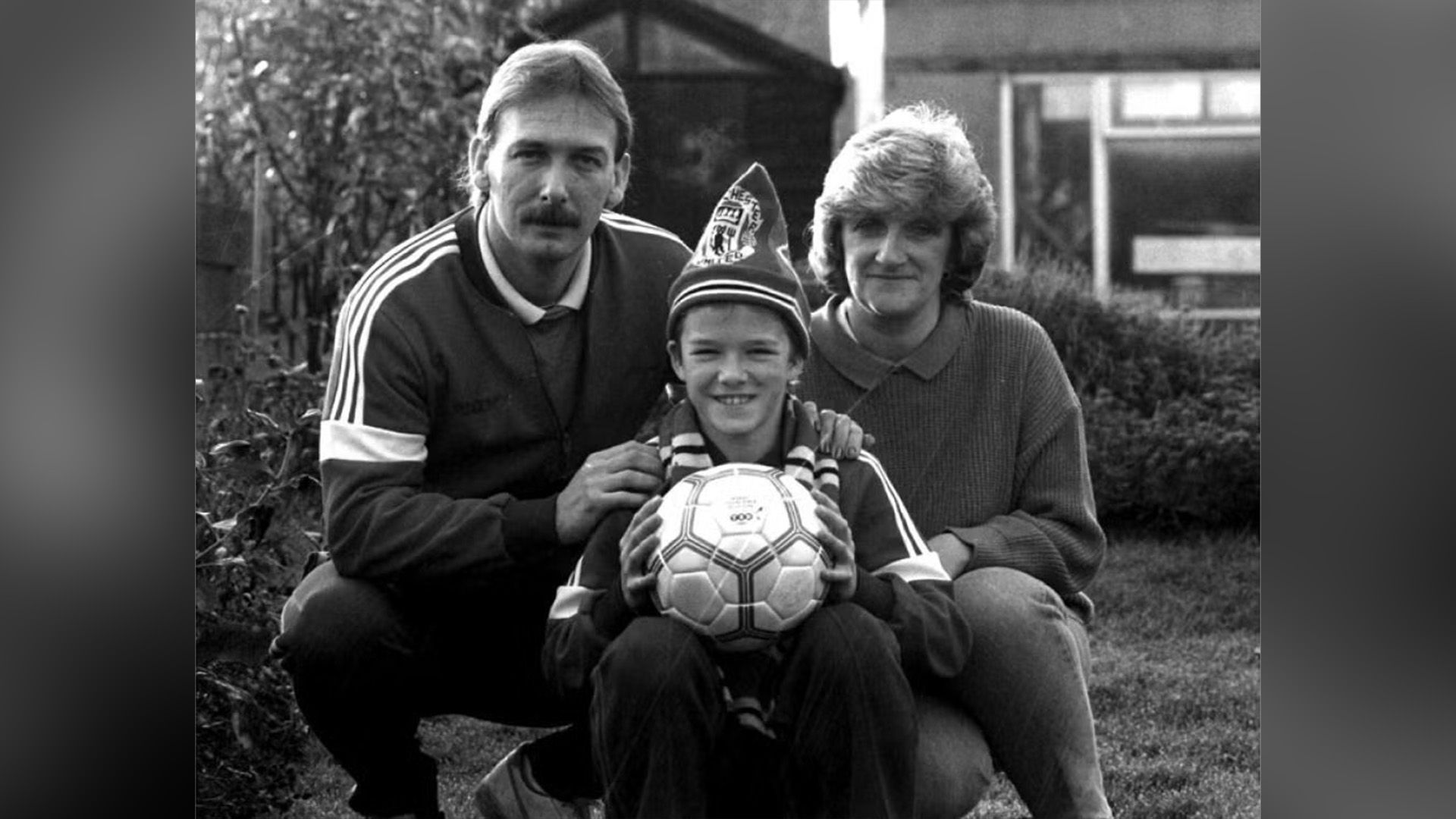 David Beckham de niño con sus padres en el césped frente a la casa