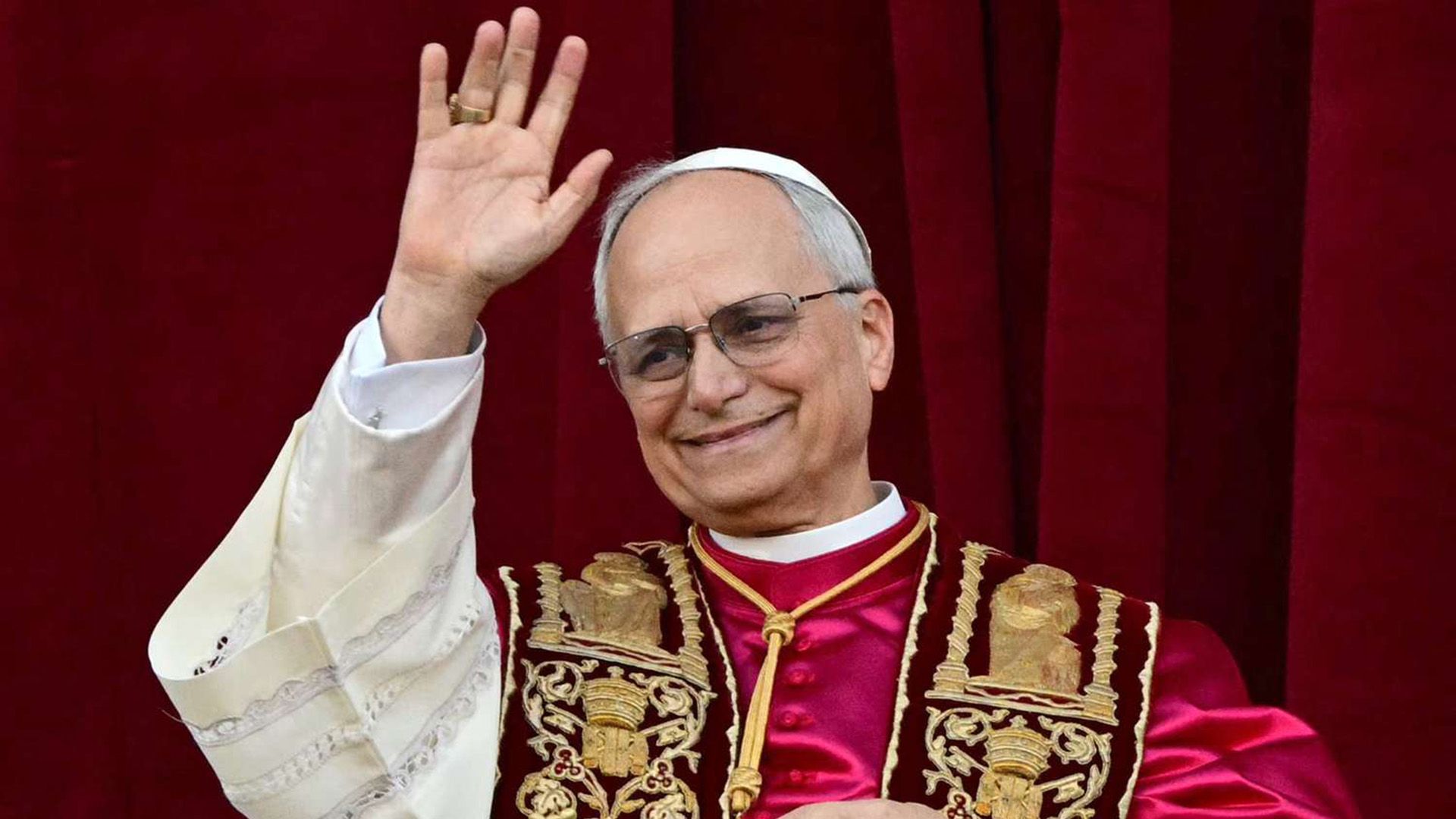 Papa León XIV (Robert Francis Prevost), vestido de rojo, saluda con la mano