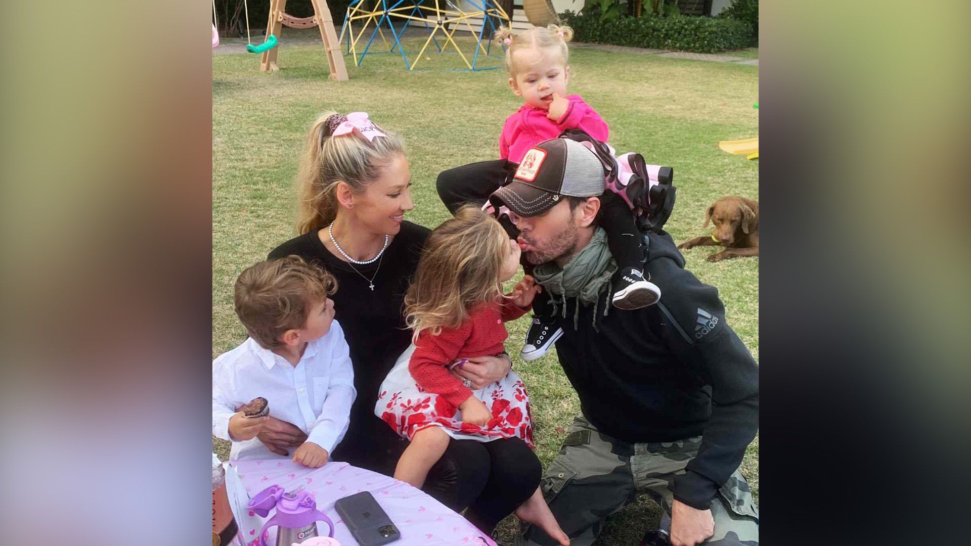 Anna Kournikova con dos niños en su regazo, Enrique Iglesias con un tercer niño sobre su hombro