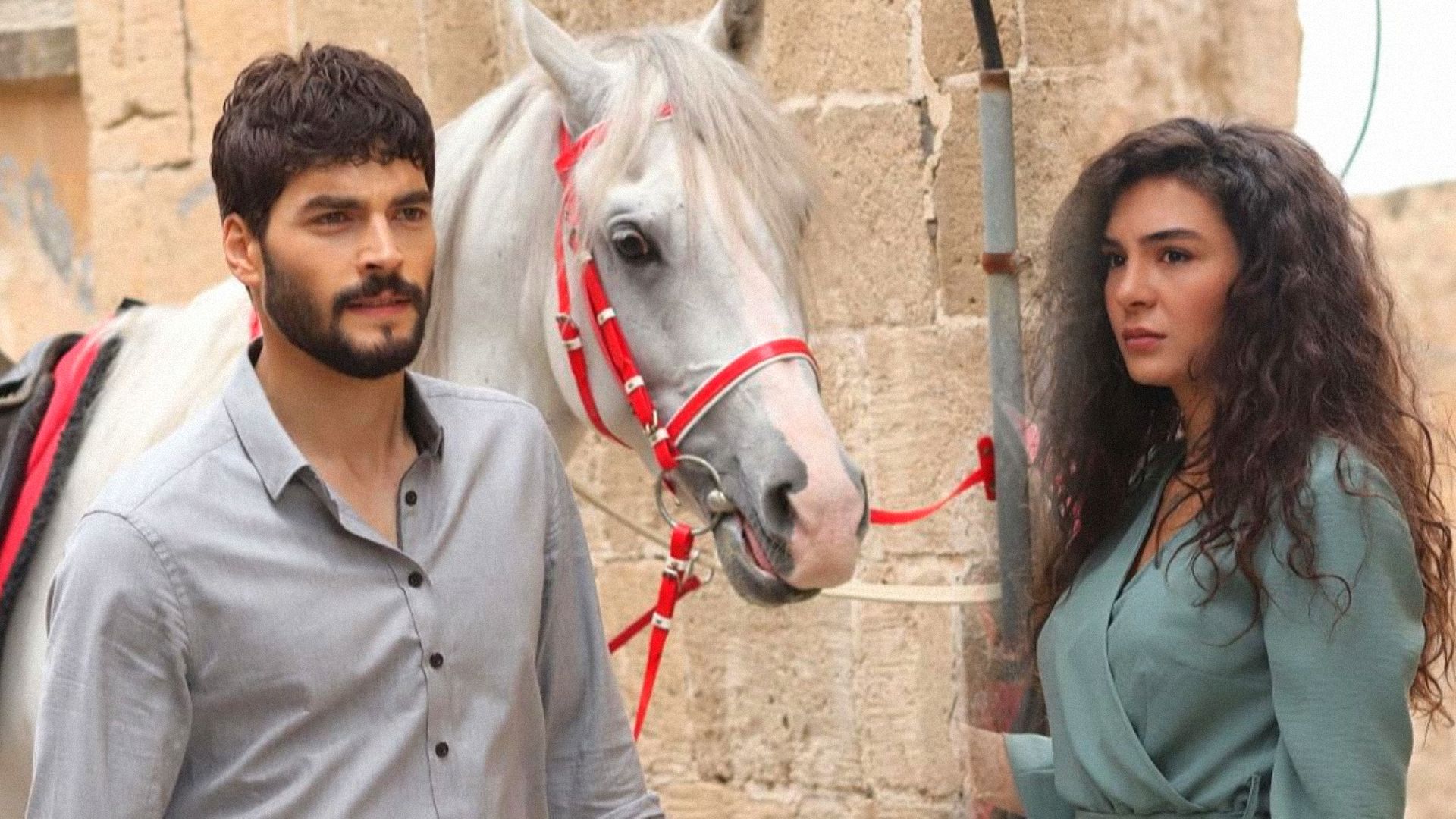 Un hombre en camisa y una chica en vestido junto a un caballo blanco